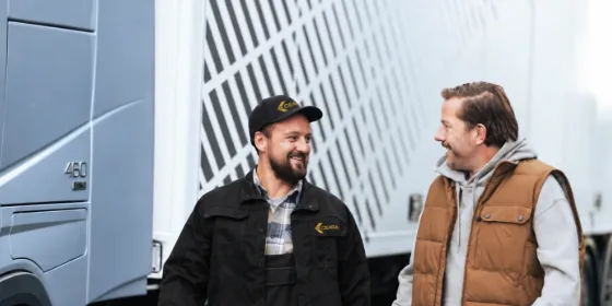 Técnico da Ceará e caminhoneiro conversando e sorrindo ao lado de um caminhão